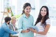 © WavebreakMediaMicro - smiling businesswomen using a tablet with colleagues