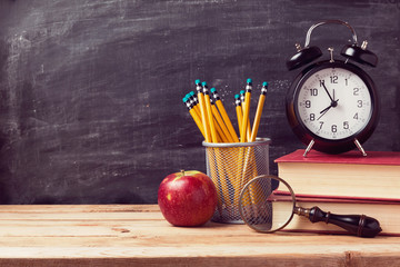 Wall Mural - Back to school background with books and alarm clock over chalkboard