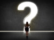 © ra2 studio - Business woman looking at wall with a bright question mark