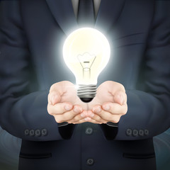 businessman holding lighting bulb