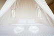 white mosquito net over a bed in a luxurious hotel