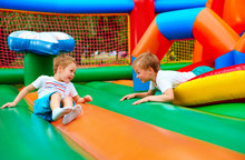 Happy Kids Having Fun On Inflatable Attraction Playground