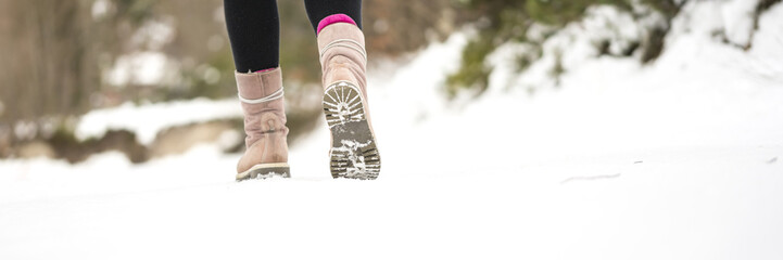 Wall Mural - Winter adventures - closeup of warm female winter boots walking