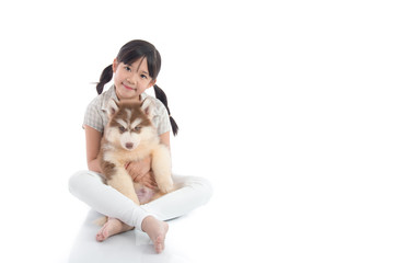 Poster - Beautiful asian girl hugging siberian husky puppy on white backg