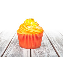 Orange Cupcake With Yellow Cream On White Wooden Background With