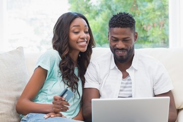 Wall Mural - Happy couple on the couch shopping online