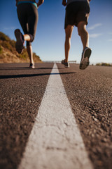 Athletes running on country road