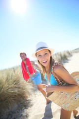 Wall Mural - Cheerful couple running to the beach in summer