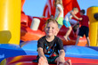© Daddy Cool - Smiling little boy sitting on a jumping castle