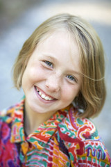 Portrait of a smiling young girl outside.