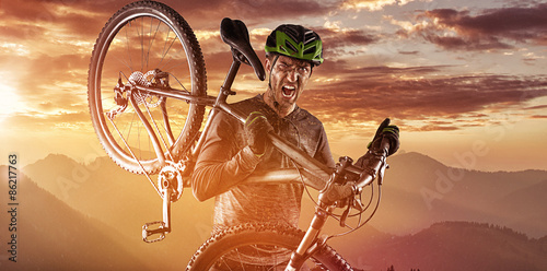 Cuadros en Lienzo Mountainbiker con la bicicleta en sus hombros