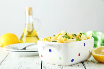 Delicious pasta with with broccoli in bowl on white wooden backg