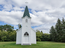 Quaint Little Country Church Sitting In A Green Meadow Surrounded By Trees In The Summer Time