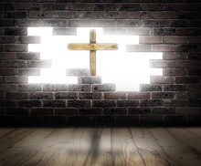 A Hole In A Brick Wall With A Wooden Cross In Front Of A Bright Light.