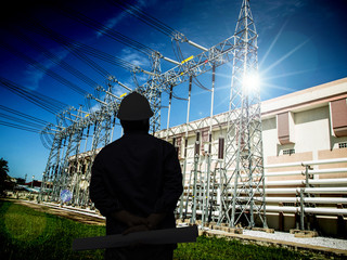 silhouette of engineers standing at electricity station