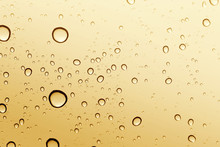 Gold Water Drop On Glass Mirror Background.