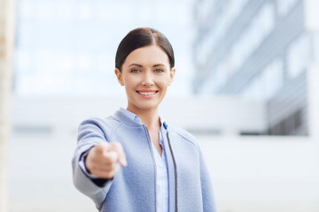 Poster - young smiling businesswoman over office building