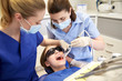© Syda Productions - female dentists treating patient girl teeth