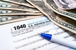 1040 individual tax return form and american dollar bills money closeup