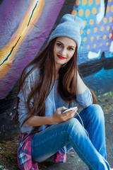 Wall Mural - Young Girl Listens to Music in White Headphones