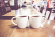 Vintage filter, couple of White coffee cup on wood table with bl