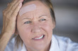 © roboriginal - Woman with painful headache and band aid