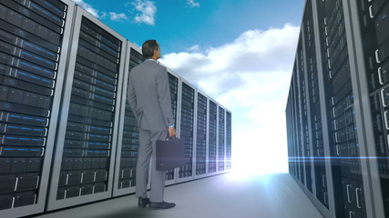 Wall Mural - Businessman looking at server tower on cloudy sky background 