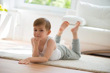 Cute little boy lying on floor