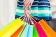 © ImageFlow - A lady in a skirt is holding a lot of colourful shopping bags.