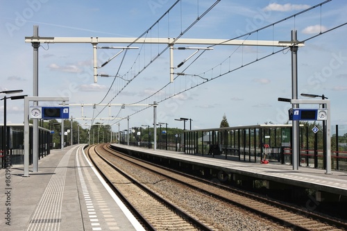 Fotomural fast menschenleerer Bahnhof an einem sonnigen Tag