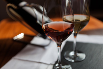 Closeup of two glasses and bottle of wine on the table