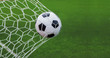 Leinwandbild Motiv soccer ball in goal with green backgroung
