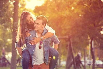 Wall Mural - young man giving piggyback in summer