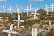 Looking Up A Graveyard Hillside Covered In White Crosses With No Names
