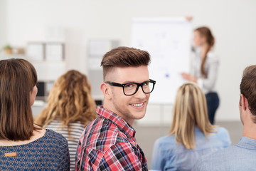 mann in einem seminar schaut lächelnd zurück
