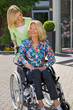Nurse with Senior Lady in Wheelchair Outdoors.