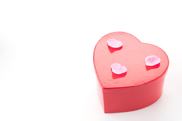 red heart gift box with white and pink rose petal on white backg