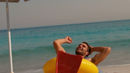 Wall Mural - Happy man wearing flippers and rising fist at the beach