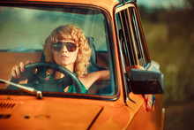 Woman Is Driving An Old Yellow Car. Rural Background.