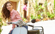 © ZoomTeam - Young beautiful italian woman sitting on a vintage scooter.