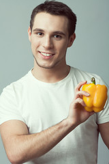 Wall Mural - Raw, living food concept. Portrait of young man with pepper