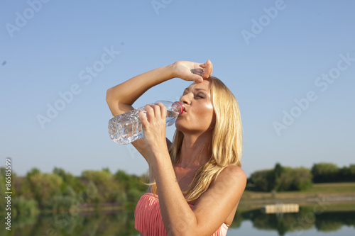 Fotografie, Obraz Junge Frau trinkt in der Hitze Mineralwasser
