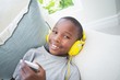 © WavebreakmediaMicro - Little boy listening to music on the couch
