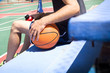 young man sitting in basketball field bleachers