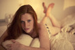 Freckled redhead in a bedroom at Sunset