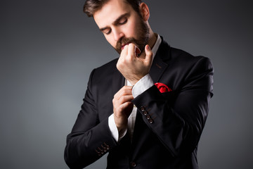 Man's style. Elegant young man getting ready. Dressing suit, shirt and cuffs