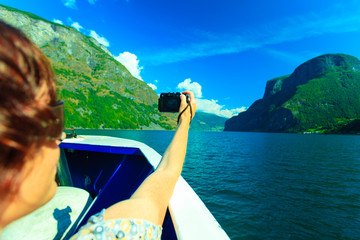 Sticker - Tourism. Woman with camera on ship, fjord in Norway.