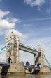 Tower Bridge London England side view with financial district buildings in the distance and red double decker bus photo vertical