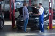 Automotive technician talking with client