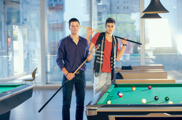 Two guys in pool billiard club playing pool billiard